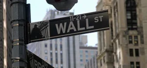 Wall Street directional sign in a financial district setting