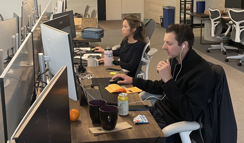 Focused team members collaborating at a workstation, Nasdaq Private Market workspace